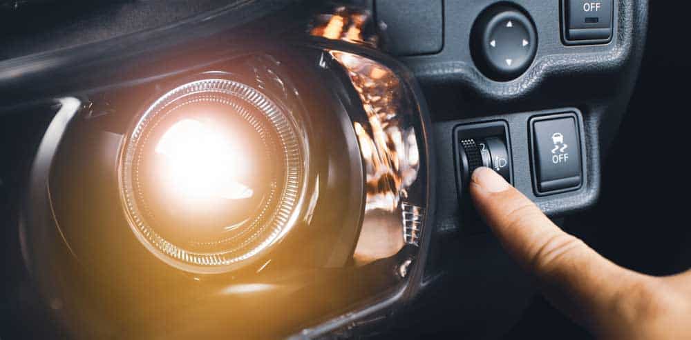 LED Projector Headlights: Driver hand adjusting headlight level