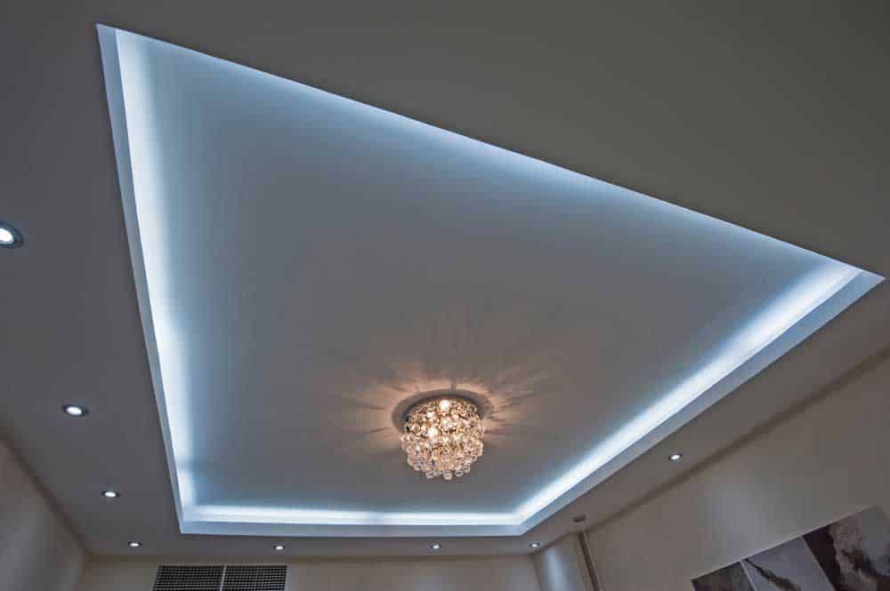 LED strip lighting surrounding an ornate-style chandelier on a drop ceiling