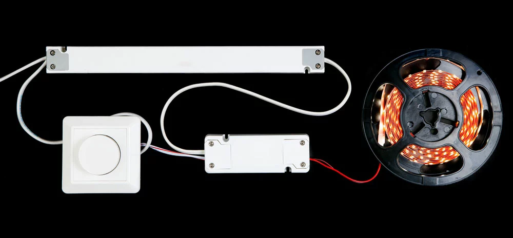An LED strip in a reel with its dimmer power supply and driver