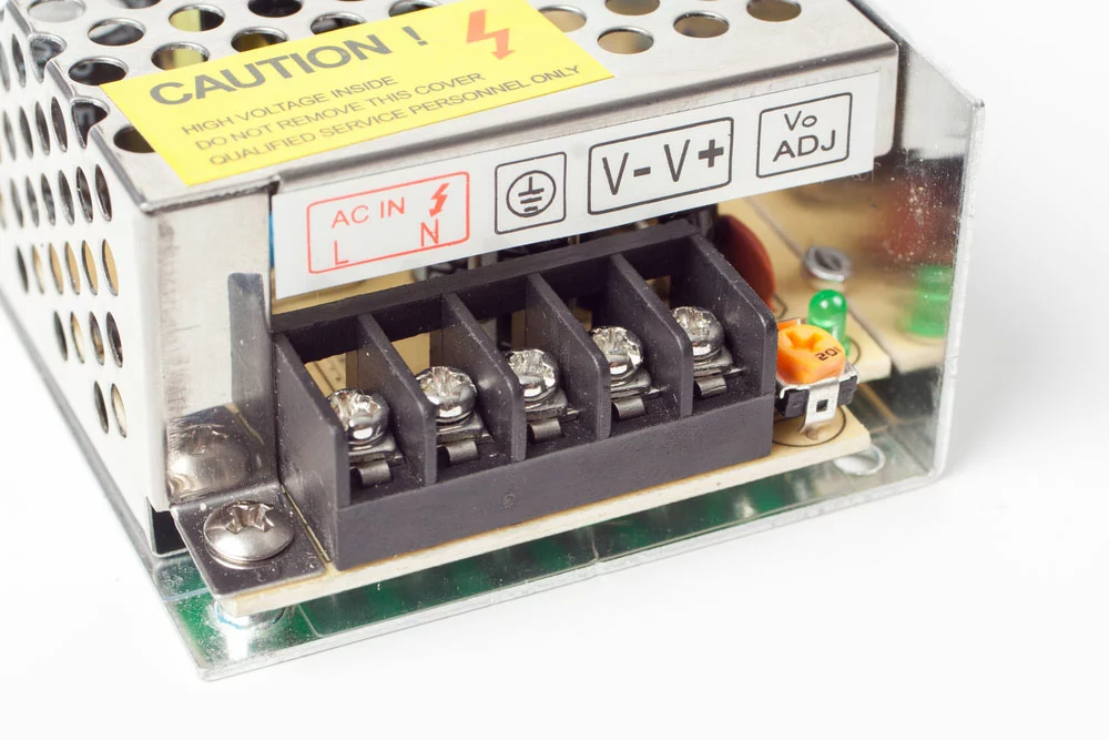 The connections of an LED strip’s power adapter. Note the line AC input and the stepped-down output voltage.