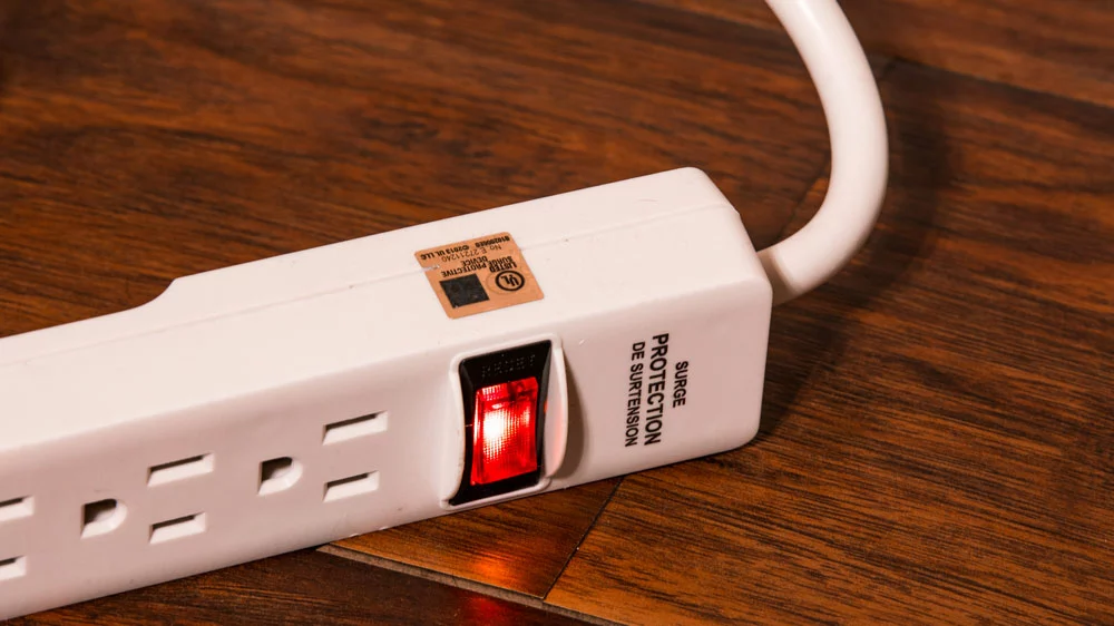 A gold sticker on a surge protector extension cord showing UL approval.
