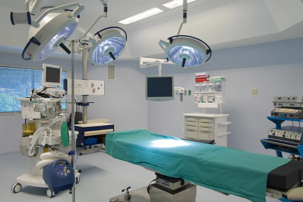 An operating room with multiple bright lights. Note the bright spot on the operating table with a high lux.