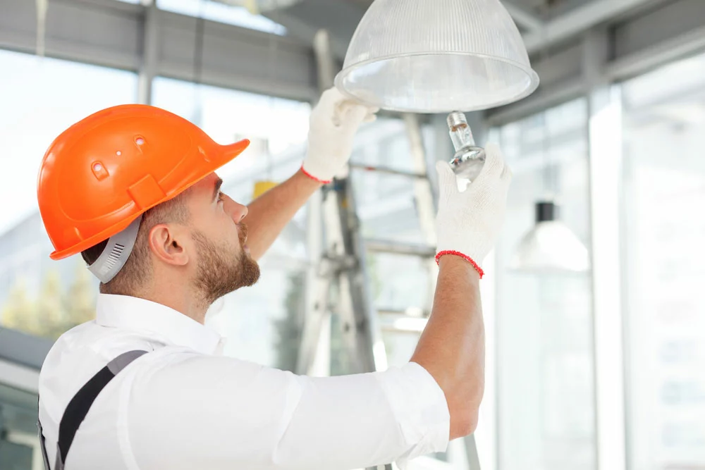 Builder screwing in a light bulb