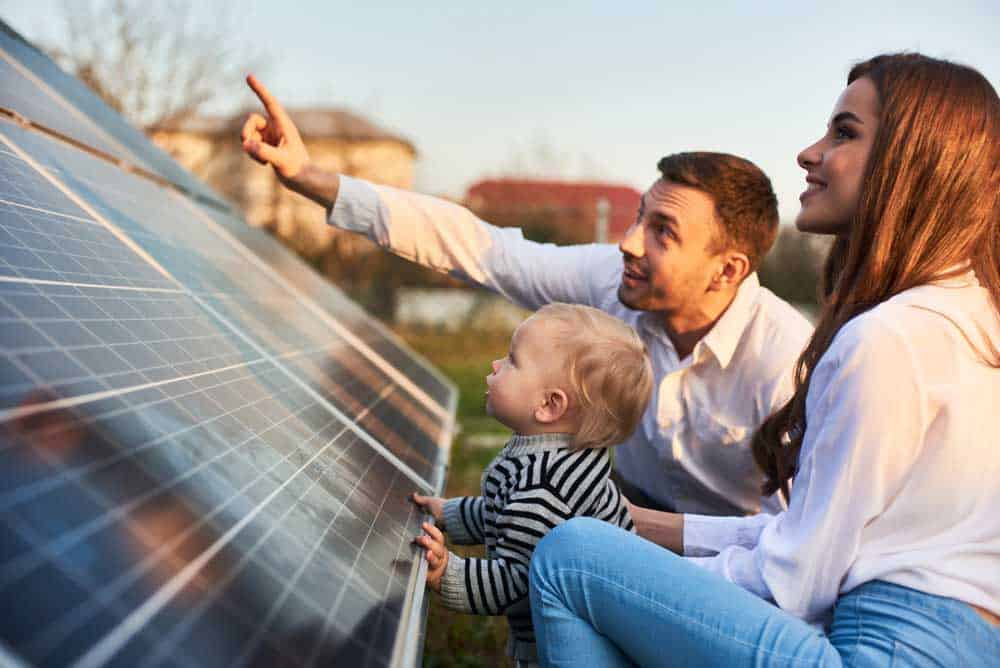 Man shows his family the solar panels
