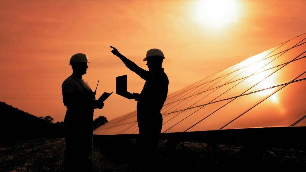 Two men in front of solar panels