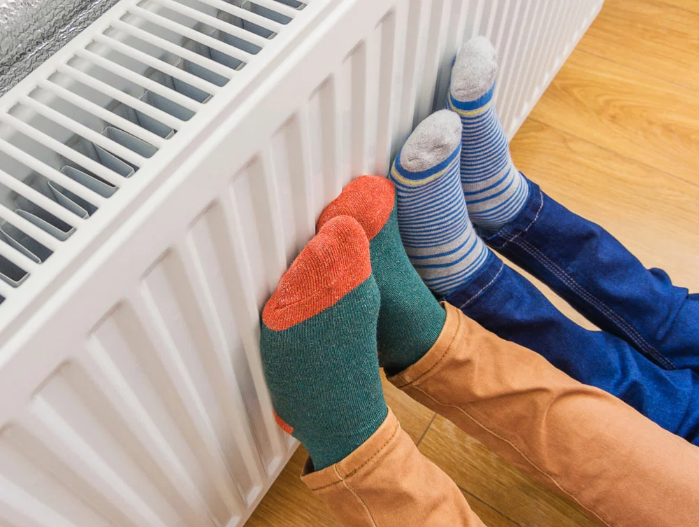 Warming cold feet on a heating radiator in wintertime.