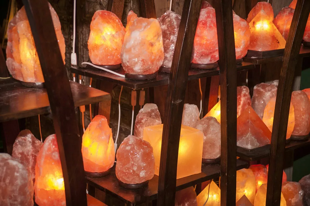 Shelves containing a collection of  salt lamps of different sizes