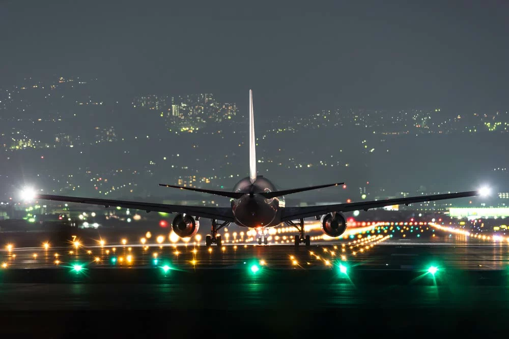 An airplane is taking off. Note the white strobe lights on the wing tips