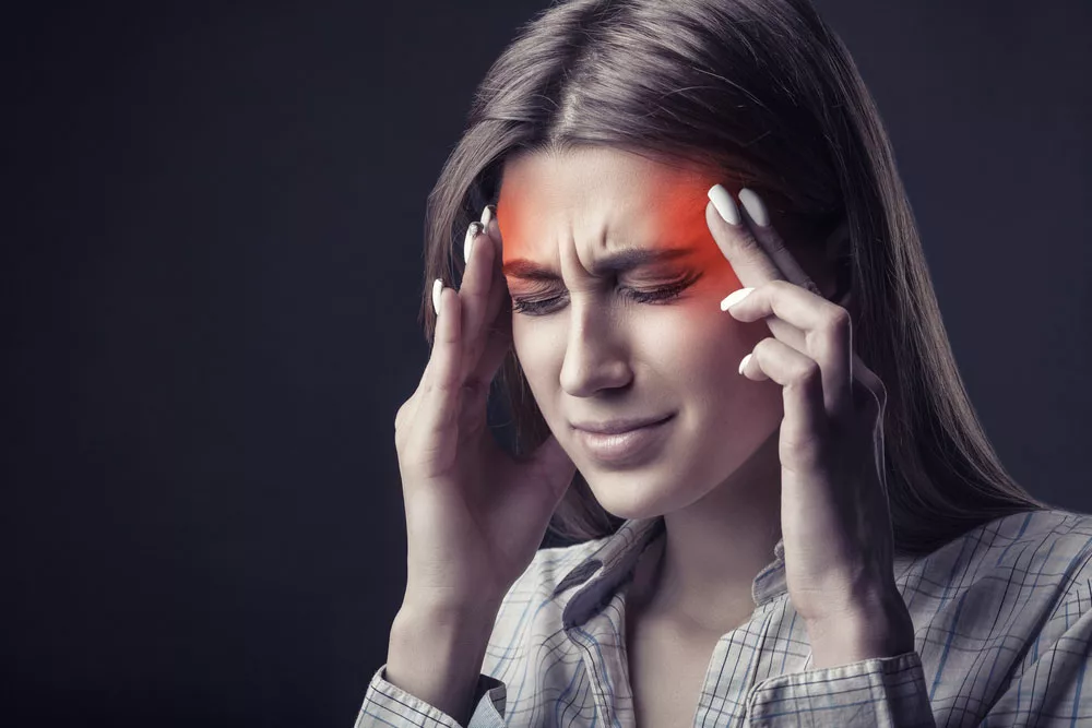 A young woman is suffering from a headache