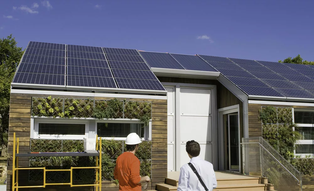 Men looking at a solar-powered house