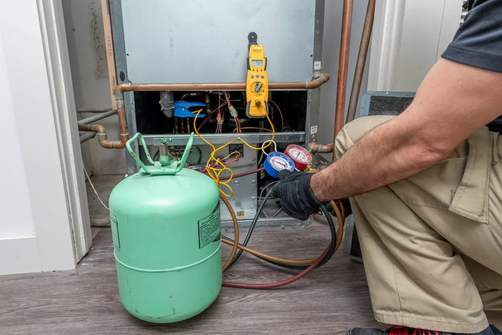 Technician changing heat pump refrigerant