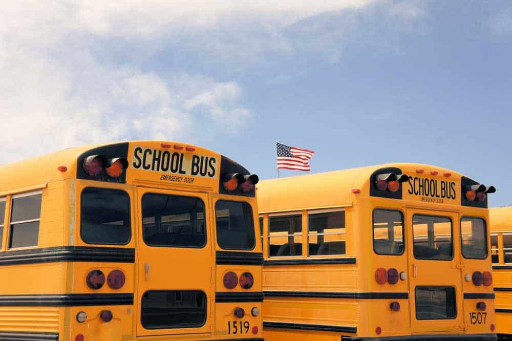 American school buses with several automotive lights. Note the red marker lamps at the top, red clearance lights, and side marker lamps
