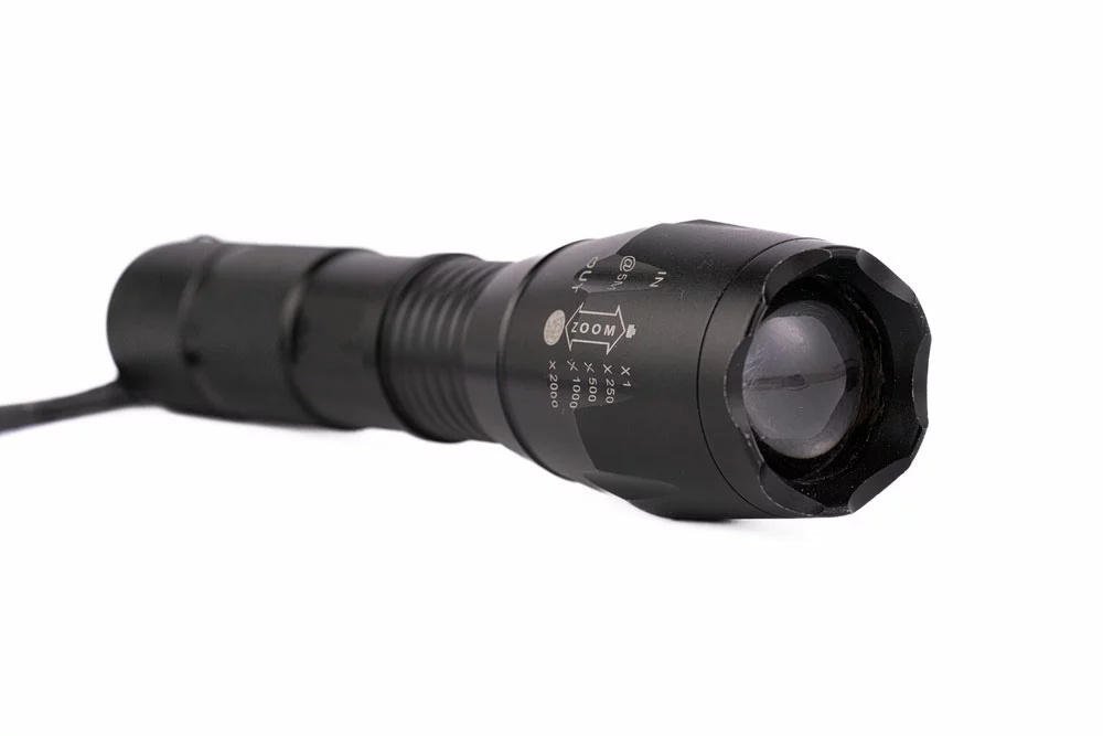 A tactical flashlight with a zooming function