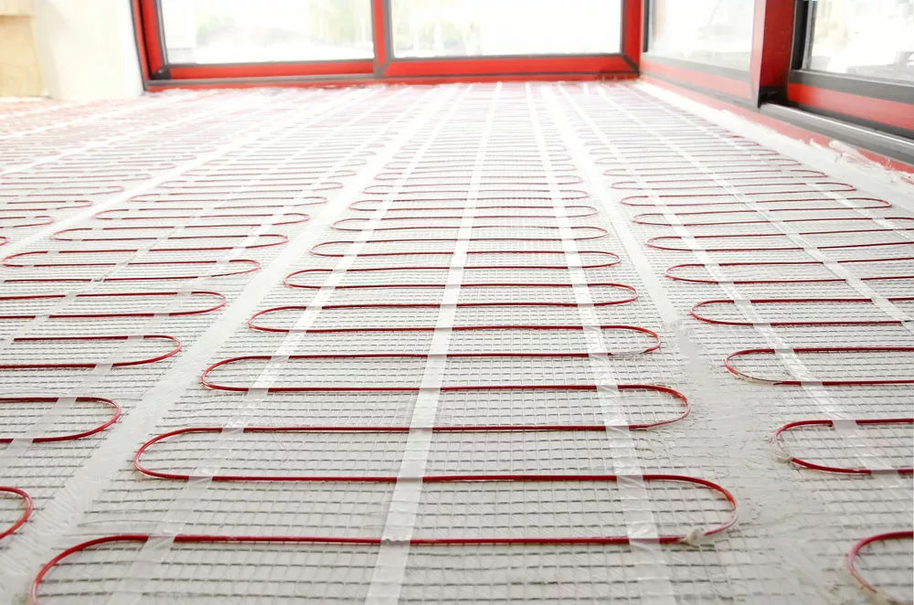 Electric underfloor heating red mats on a cement floor